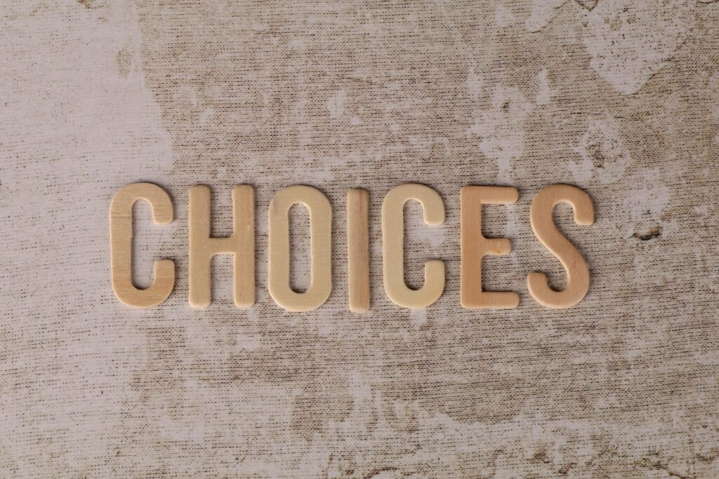 Wooden letters spelling 'choices' on a textured surface, symbolizing decision-making.